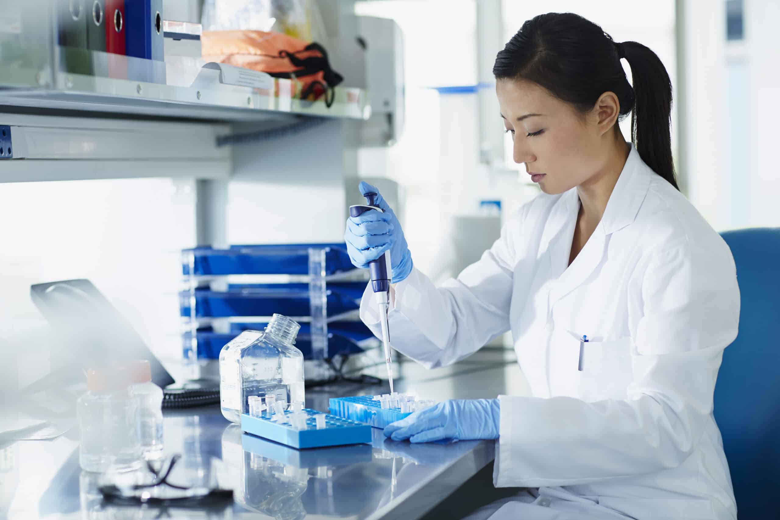 Scientist pipetting samples into eppendorf tubes in research laboratory